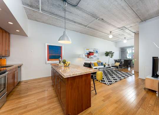 A kitchen with wooden floors and a large island in the middle.
