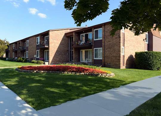 Apartment building with a flower bed in front.