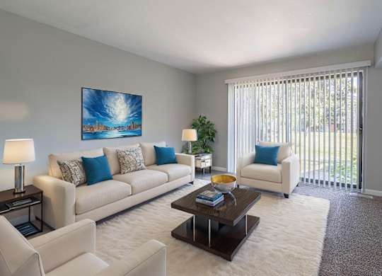 A living room with a white couch, a coffee table, and a painting on the wall.