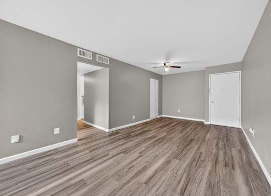 A room with wooden flooring and white walls.