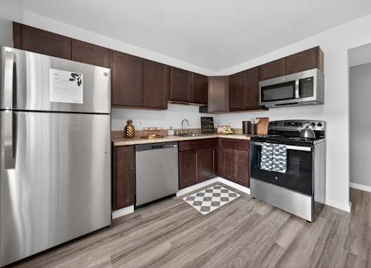 A kitchen with a stainless steel refrigerator and microwave.