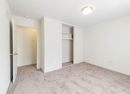 A room with a carpeted floor and a white door.