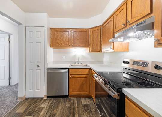 A kitchen with wooden cabinets and a black stove top oven.
