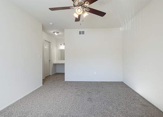 A room with a ceiling fan and carpeted floor.