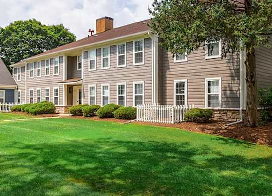 A large house with a white picket fence in front.