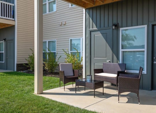 a patio with a table and chairs in front of a house