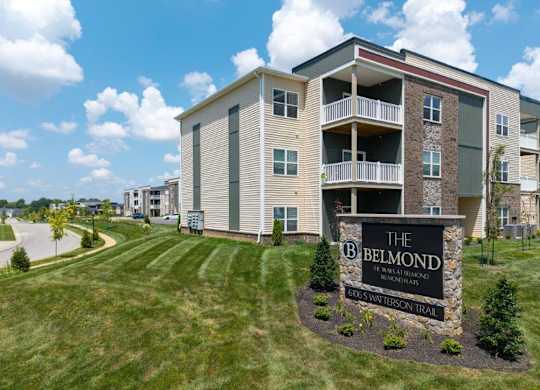 The Belmond apartments are located in a grassy area with a clear blue sky.