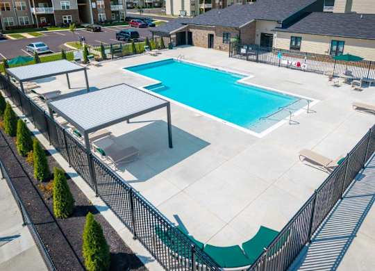 A large outdoor swimming pool surrounded by a black fence.