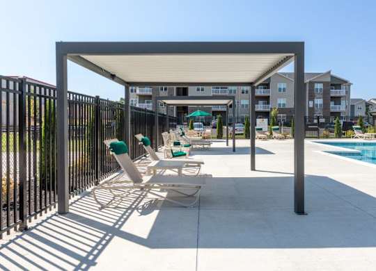 A poolside area with a black fence and a white canopy.