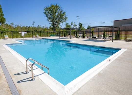 A large outdoor swimming pool with a metal railing.