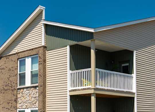 A house with a balcony and a stone pillar.