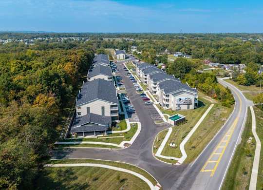 A road with a yellow line on the right side and houses on the left.