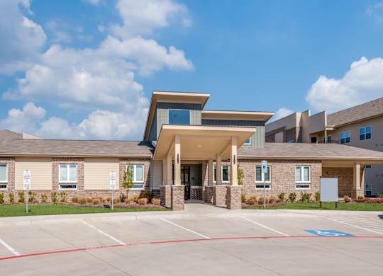 A modern building with a parking lot in front.