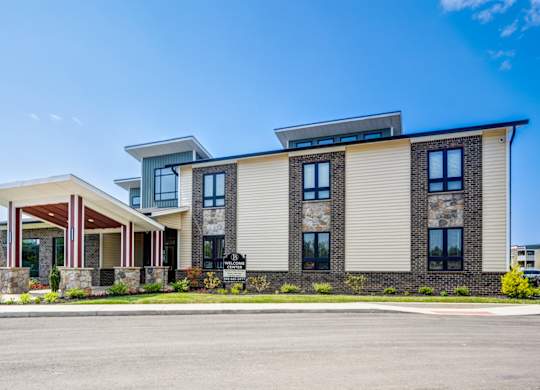 A modern two-story building with a mix of stone and siding exterior.