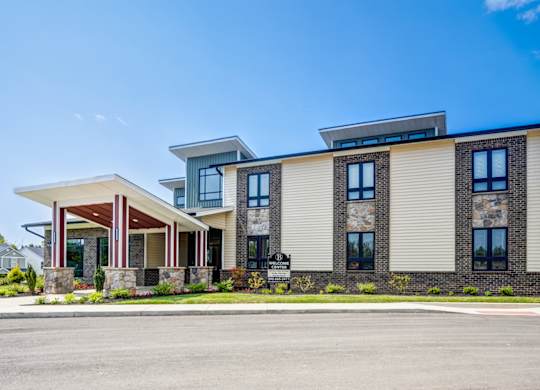 A modern two-story building with a mix of stone and siding exterior.