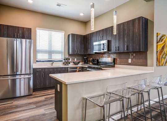 A kitchen with a white counter top and a refrigerator.