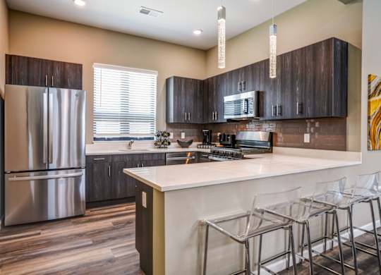 A kitchen with a white counter top and a refrigerator.