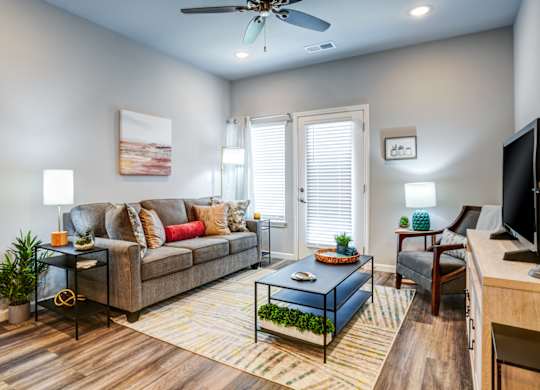 A living room with a couch, a coffee table, and a television.