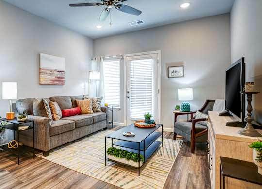 A living room with a couch, a coffee table, and a television.