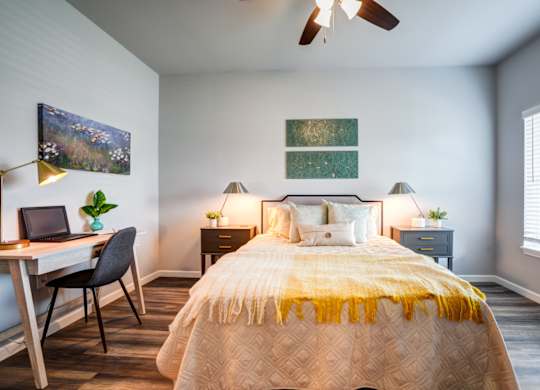 A bedroom with a bed, desk, and chair.