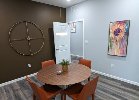 a dining room with a wooden table and orange chairs
