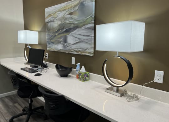 a large desk with a computer and lamps on it