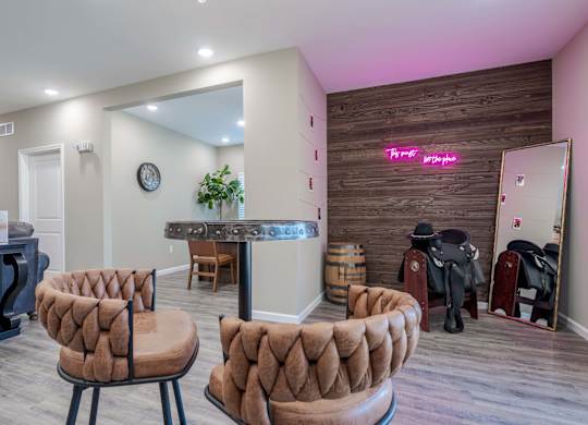 Two brown chairs are in front of a wooden wall.
