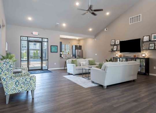 A living room with a white couch and a chair with a patterned cushion.