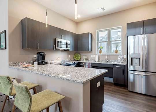 A kitchen with a granite countertop and stainless steel appliances.