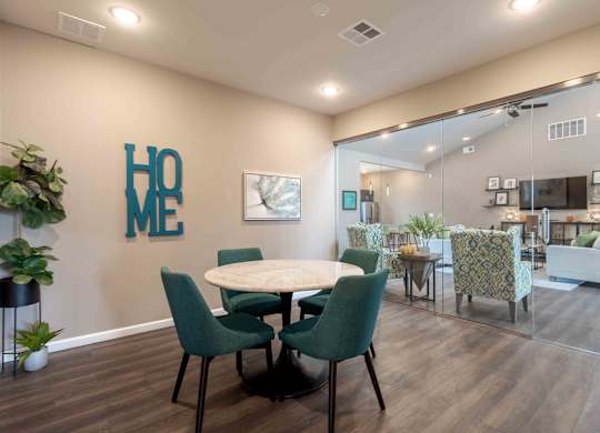 A dining room with a table and chairs and a plant.