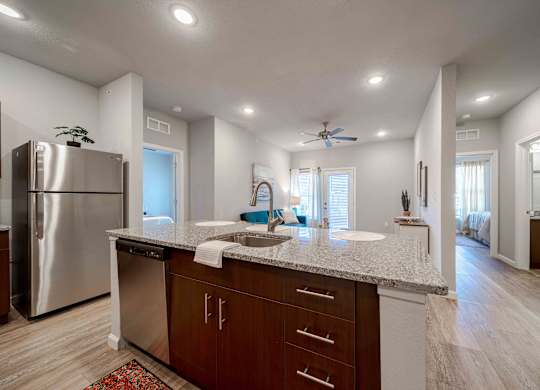 a kitchen with a granite counter top and a stainless steel refrigerator