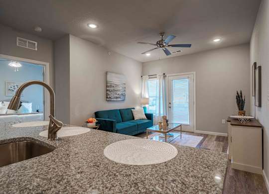 view of living room from kitchen with granite counter top and sink