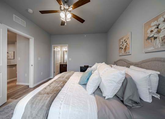 a bedroom with a large bed and a ceiling fan