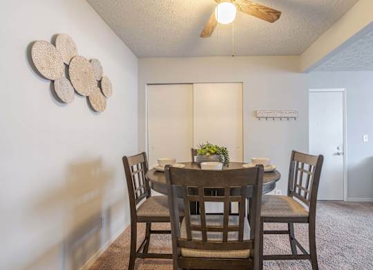 A dining room with a table and chairs.