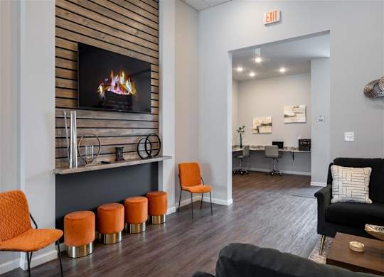 a living room with a fireplace and orange stools