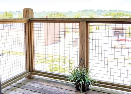 a balcony with a fence and a potted plant on it
