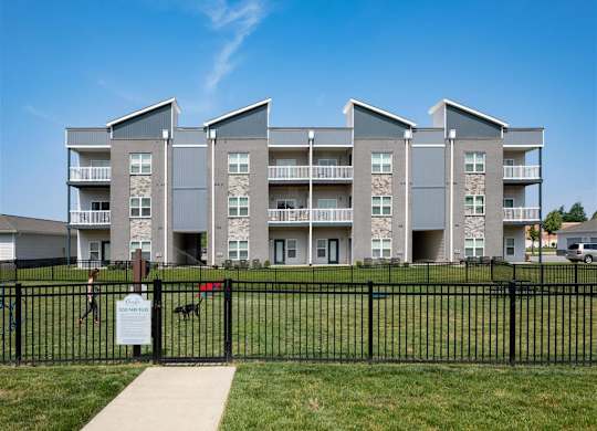 an apartment building with a black fence in front of it