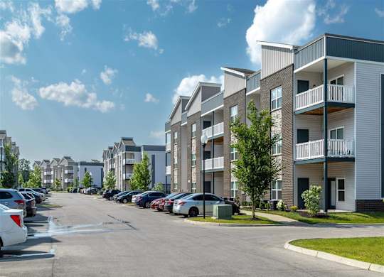 an empty parking lot in front of an apartment building
