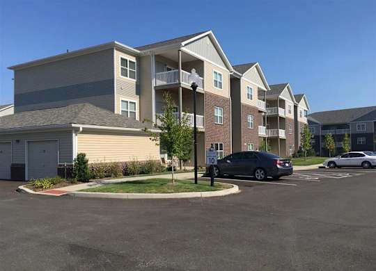 an empty parking lot in front of an apartment building