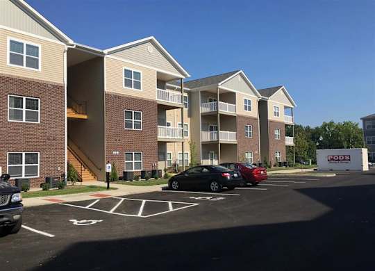 an empty parking lot in front of an apartment building