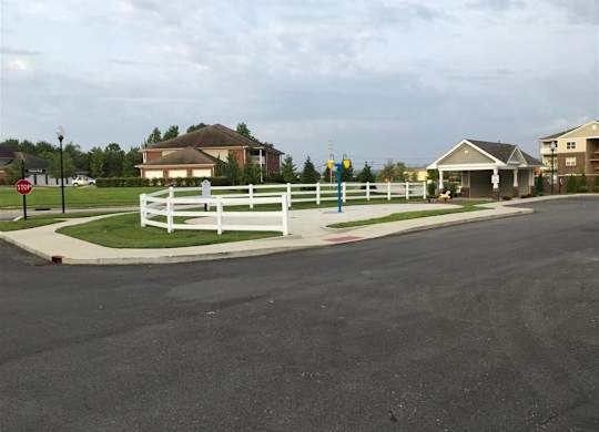 a street corner with houses and a white fence