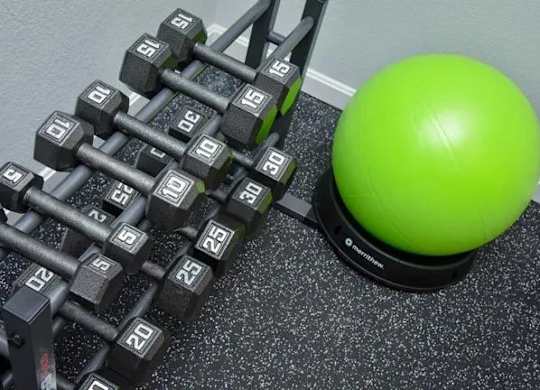 a pile of weights next to a green ball