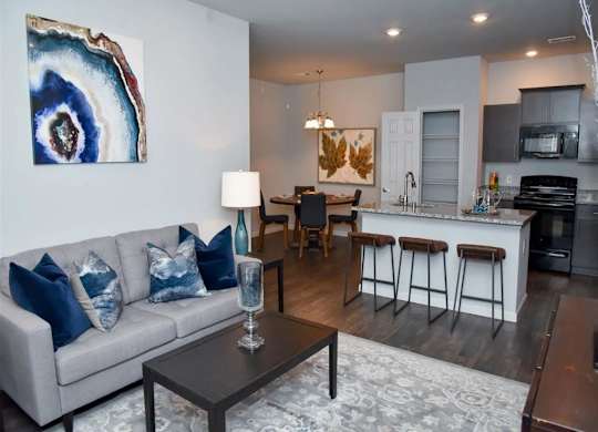 a living room and kitchen with a couch and a table