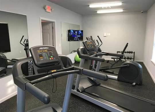the gym in our new building is equipped with a treadmill and a tv