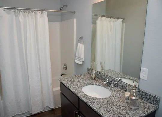 a bathroom with a white shower curtain and a sink