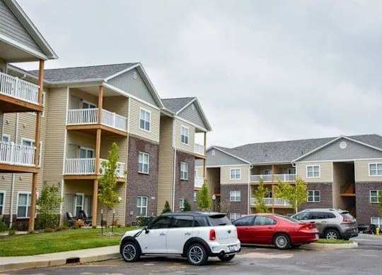 a row of cars parked in front of an apartment building