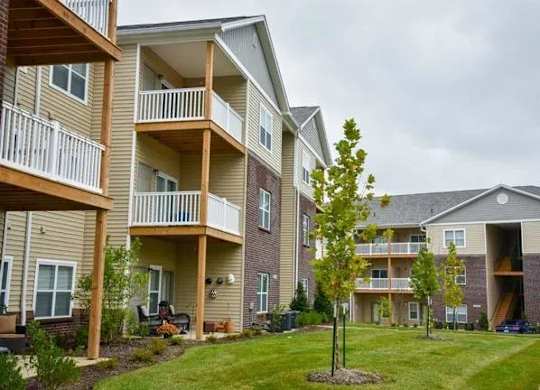a row of apartment buildings with balconies and trees