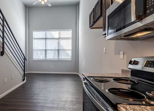 A kitchen with a stove top oven and microwave above it.