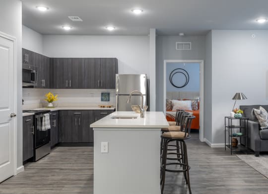 a kitchen and living room with a white counter top and