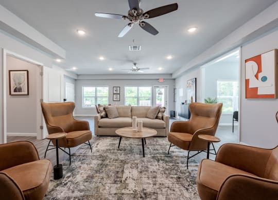 a living room with couches and chairs and a ceiling fan